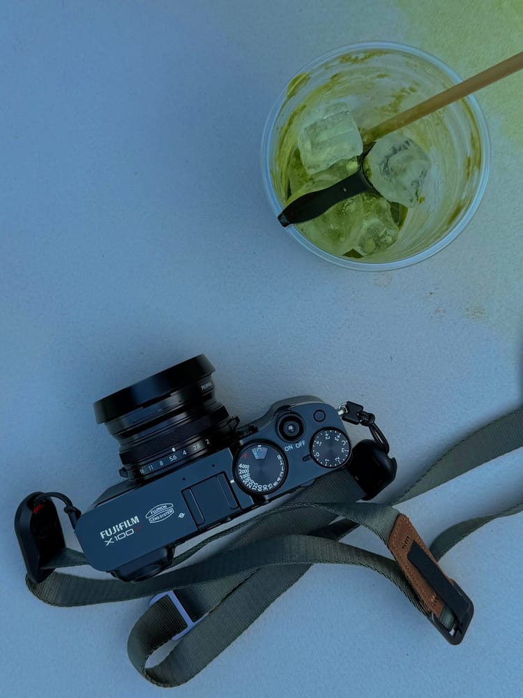 A Fujifilm X100VI camera and an iced green drink on a table